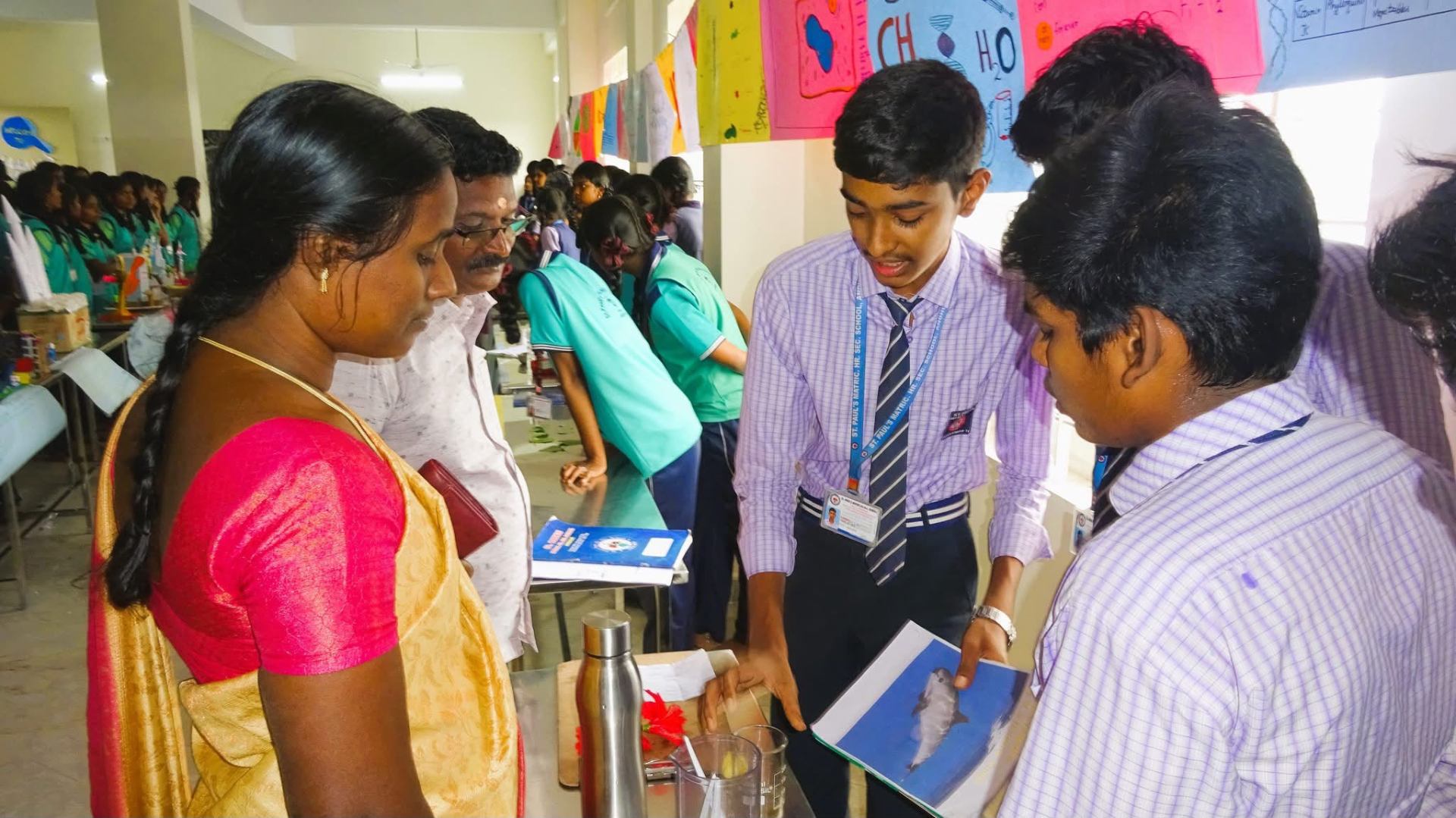 Senior students explaining science exhibits to visiting parents