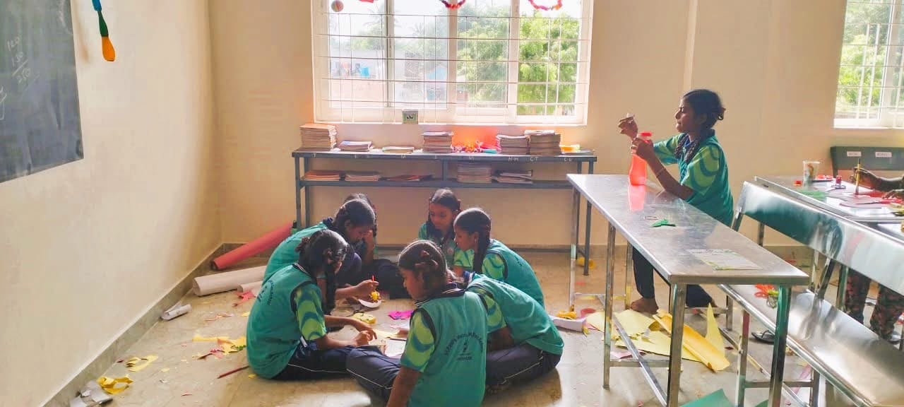 Girls working together on paper craft in the art and craft classroom