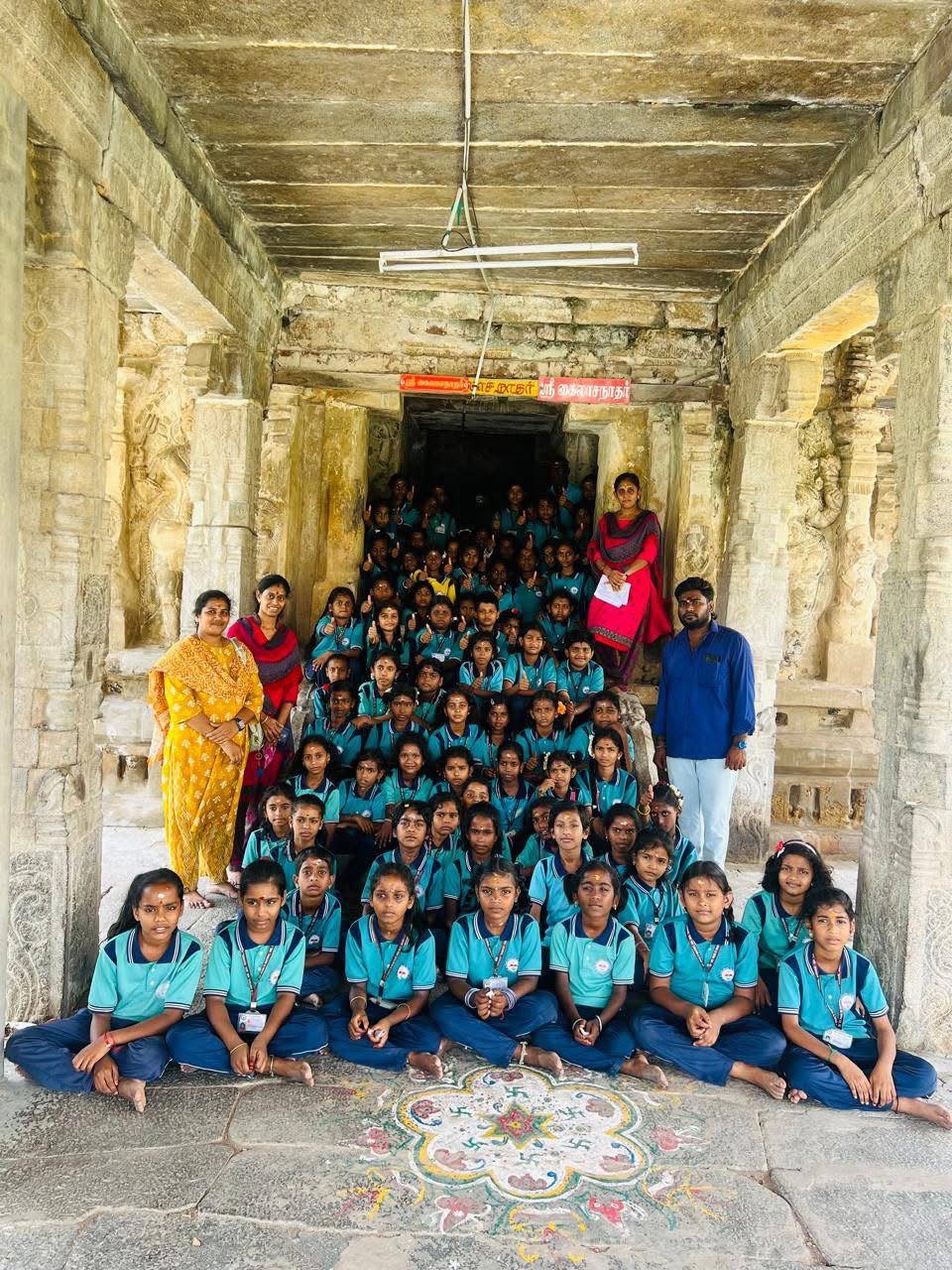 Large group of students with teachers at the entrance of an ancient temple during a study tour