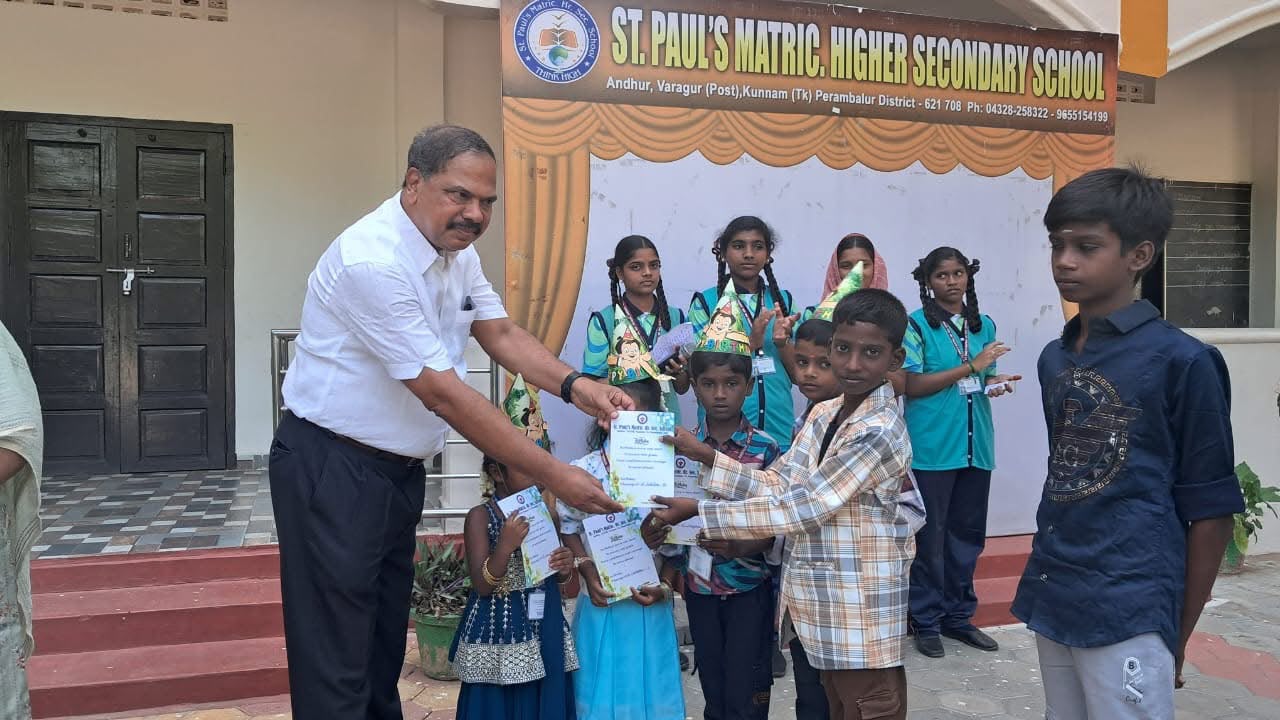 Principal presenting achievement certificates to primary students on stage